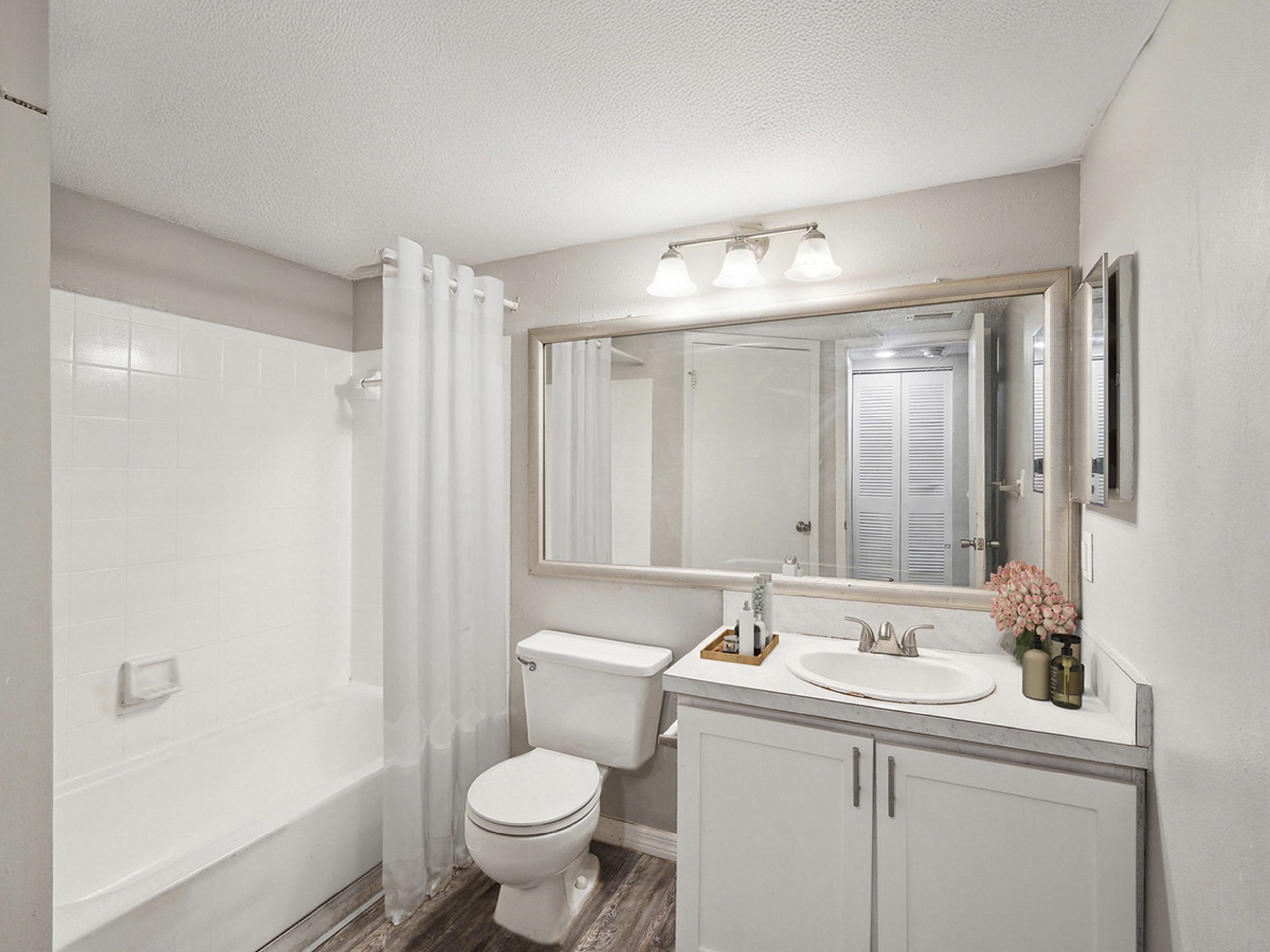 a bathroom with a white tub and toilet at The  Brady at Tampa Palms