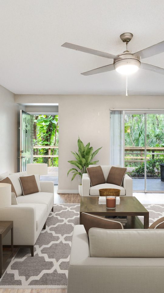 a living room with a ceiling fan and hardwood floors at The  Brady at Tampa Palms